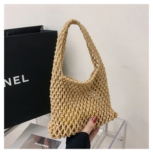 Detail of hand-held beige woven mesh bag with yellow lining in bohemian minimalist style