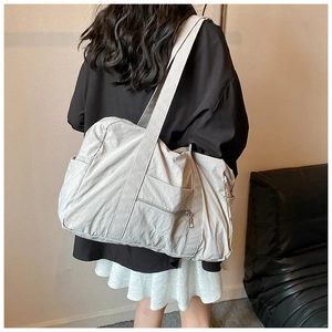 Detail of durable nylon shoulder bag featuring side pockets and a spacious main interior