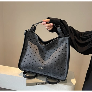 Gray fabric tote bag with black bow pattern and leather trim for stylish casual commute