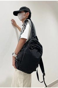 Detail view of large black waterproof nylon backpack featuring adjustable side buckles
