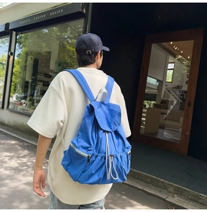 Detail of royal blue nylon backpack showing drawstring closure and wrinkled texture