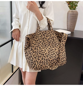 Leopard print canvas tote bag shown as a crossbody with wide strap and hand straps