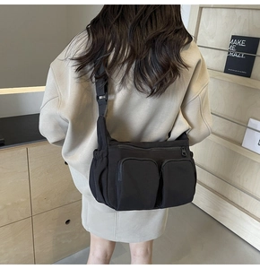 Close-up of black nylon messenger bag with multi-pocket design and adjustable strap