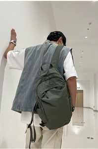 Detailed back view of a dark olive green nylon backpack with textured wash fabric finish