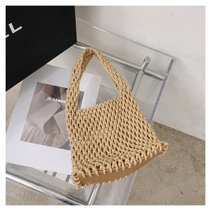 Macro view of minimalist woven straw handbag featuring hollow mesh texture and smooth brown base