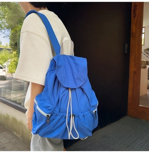 Detail of royal blue nylon backpack showing the wrinkled texture and white drawstring