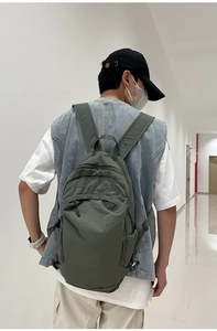 Close-up of a dark green washed nylon backpack with water-resistant fabric on a model