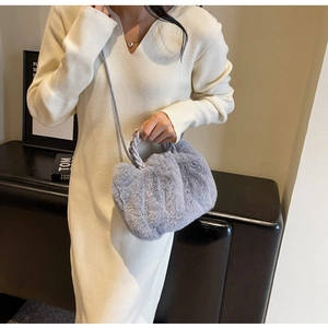 Detail shot of grey faux fur crossbody bag with vertical stripe texture and woven handle