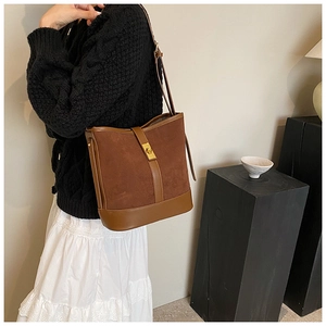 Detail of caramel faux suede crossbody bag with gold metallic twist-lock closure