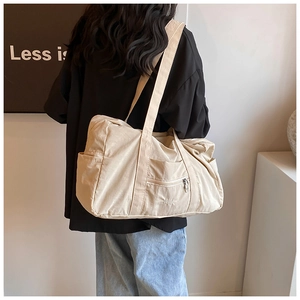 Detail view of beige nylon tote bag with VETLA embroidery and wide shoulder strap