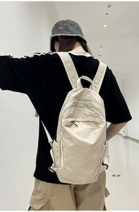 Macro detail of cream washed nylon backpack featuring shoulder straps and FLY10 logo