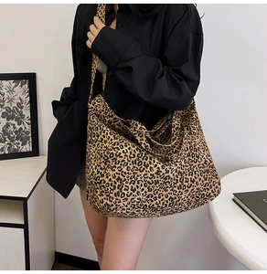 Detailed view of large leopard print canvas tote bag styled with casual black shirt