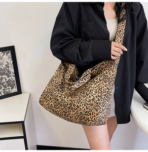 Detail view of large leopard print canvas tote bag showing crossbody style and textile texture