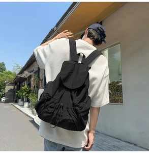 Detail showing high-quality nylon fabric texture and side zipper on a black backpack
