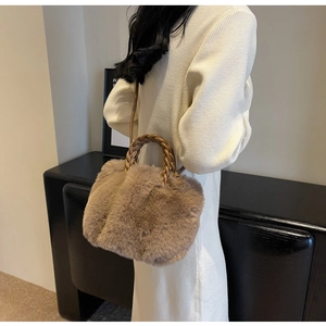Close-up of khaki plush crossbody bag with woven handle on a model in knit dress