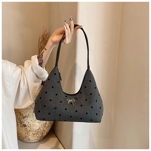 Dettaglio borsa a luna in denim grigio con fiocco in metallo argento e pois vintage