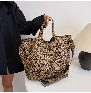 Detailed view of leopard print canvas tote bag with dual handles and shoulder strap