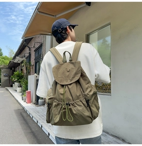 Close-up of olive green nylon backpack with drawstring closure and durable fabric texture