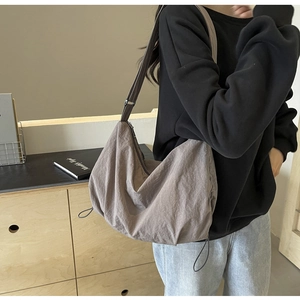 Detail view of the pleated texture and adjustable strap on the taupe crossbody bag