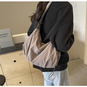 Detail of a large taupe nylon tote bag showing natural crinkled texture and spacious design