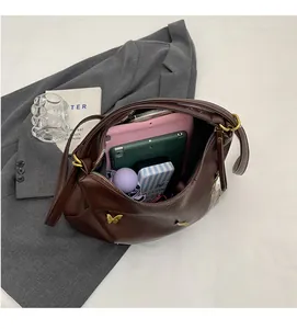 Spacious interior of brown PU handbag showing storage for tablets and accessories