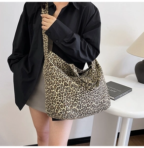 Large leopard print canvas hobo bag worn by model in a minimalist lifestyle setting