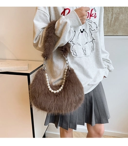 Détail rapproché du sac à bandoulière en peluche marron avec chaîne de perles élégante