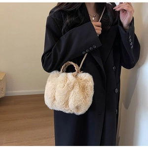 Detailed view of beige faux fur crossbody bag with braided handles and soft texture