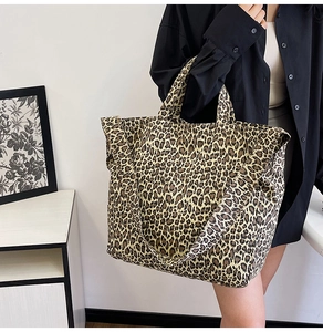 Detail of leopard print canvas tote bag featuring handle and wide shoulder strap