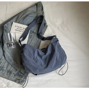 Minimalist navy blue nylon crescent crossbody bag for women on white fabric background