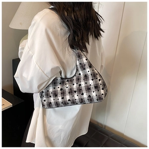 Dettaglio della borsa hobo con motivo a quadri bianco e nero, cuori e fibbia dorata