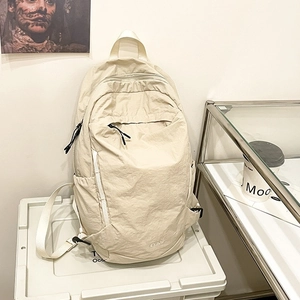 Minimalist cream-colored nylon backpack with FLY 10 logo on a modern storage box