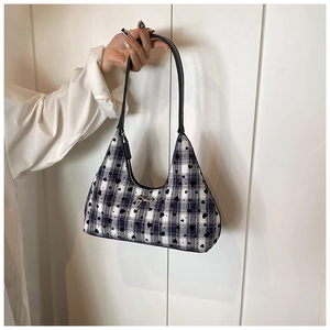Dettaglio della borsa a tracolla a scacchi blu con cuori e fiocco dorato chic