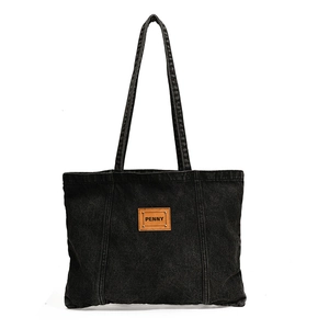 Minimalist black washed denim tote bag with brown leather Penny tag and silver rivets