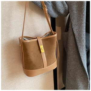 Detail of vintage brown faux suede bucket bag with gold clasp and adjustable strap