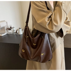 Detail of dark brown PU leather tote with 3D golden butterfly metal accessories