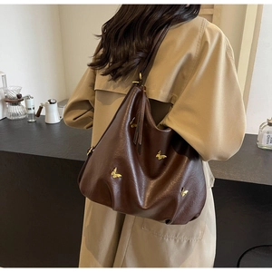 Detail of dark brown PU leather hobo bag featuring golden butterfly metal ornaments