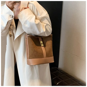Detail of caramel faux suede bucket bag with gold metal twist lock and shoulder strap