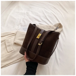 Dark brown faux suede bucket bag with gold rotary lock and leather patchwork