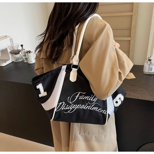 Detail view of large nylon tote bag with black and white color block and number print