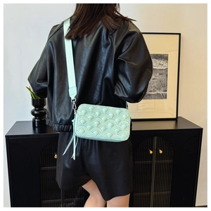 Borsa a tracolla quadrata verde menta con trapuntatura a onde e tracolla larga su modella