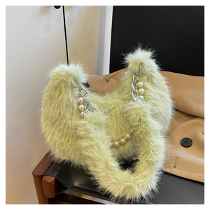 Détail du sac à main en peluche vert avocat avec fausse fourrure et chaîne de perles chic