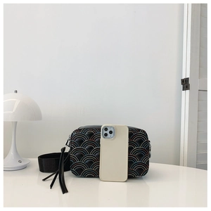 Dettaglio del ricamo a scaglie colorate su borsa a tracolla in ecopelle nera con frange