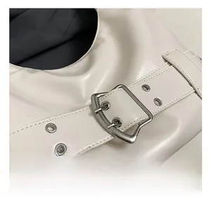 Close-up of white glossy leather handbag with premium silver metal buckle detail