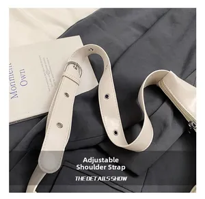 Close-up of adjustable strap on beige PU shoulder bag with silver metal eyelet details