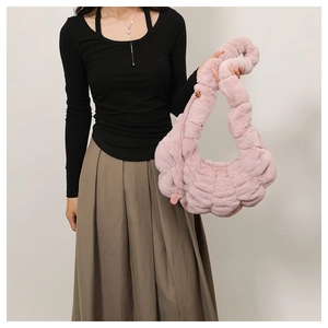 Detail van roze imitatiebont cloud bag met pluizige geweven textuur en zachte grip