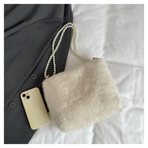 Détail du sac à bandoulière en fausse fourrure douce avec double chaîne en perles et fermoirs dorés