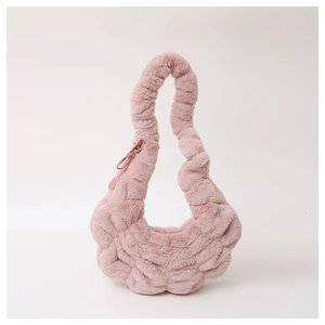 Detail van roze pluche croissant tas met geplooide handvatten en zachte imitatiebont