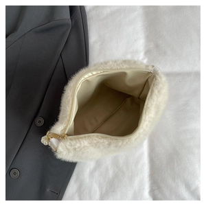 Détail de l'intérieur du sac en peluche montrant la doublure beige et la fermeture éclair