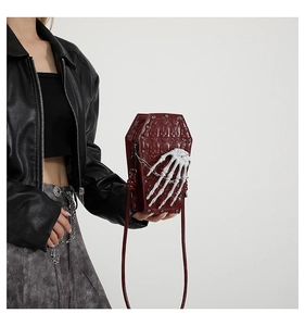 Detail of coffin-shaped bag with skull texture and 3D skeletal hand decoration